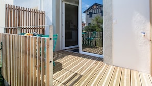A wooden deck with a sliding glass door leading to an outdoor seating area. - Cap Océan by Interhome (Capbreton)