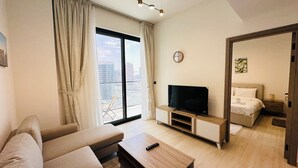 Una habitación de hotel moderna con un ventanal grande, un televisor de pantalla plana, un sofá y una cama.
