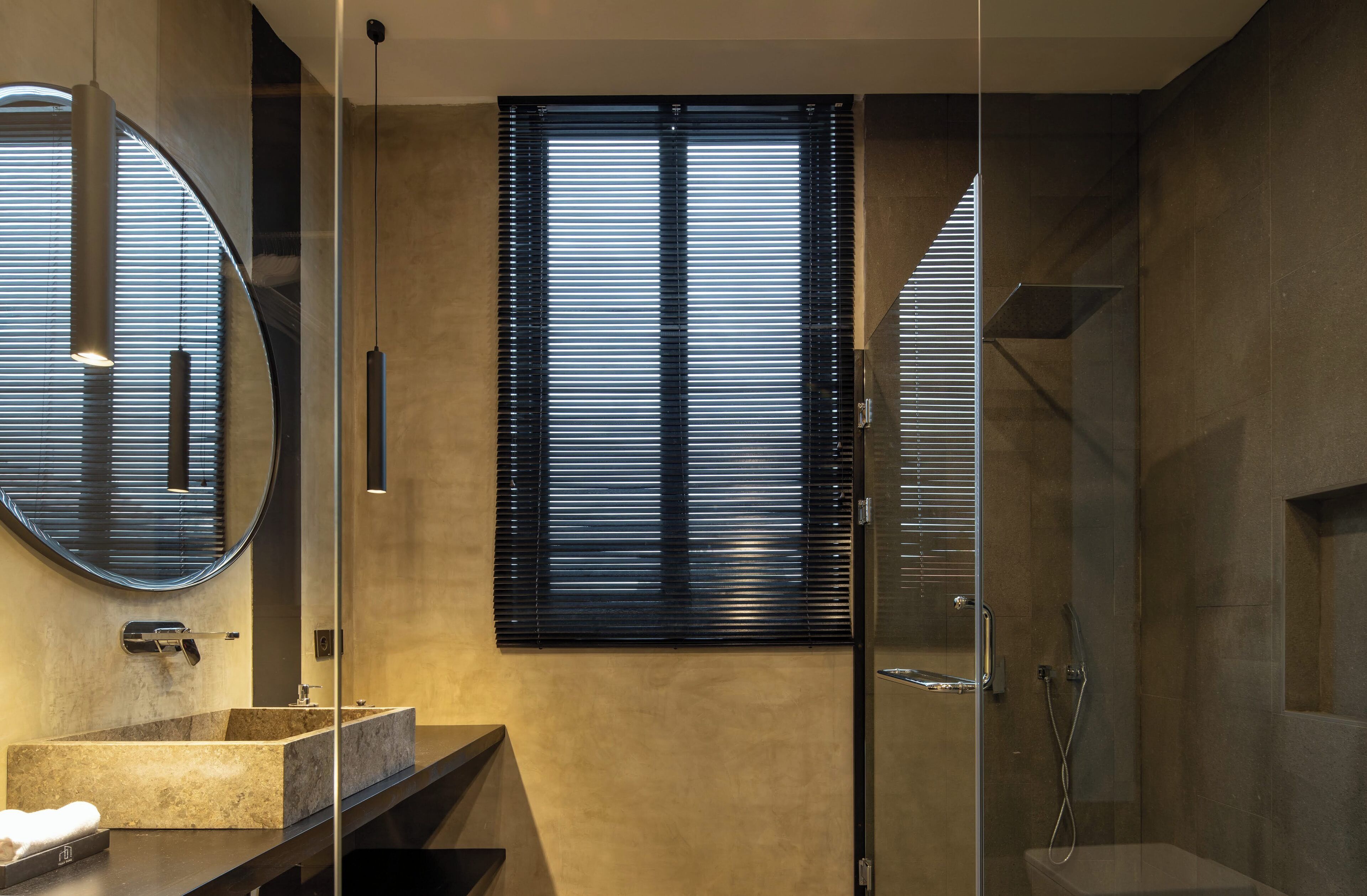 A modern bathroom with a large mirror, a sink, and a shower area.