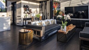 A modern living room with a large TV, a sofa, and a coffee table. - Villa Gima 1 (Kerobokan)