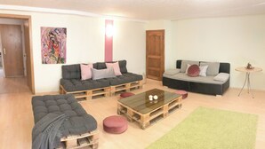 A living room with two sofas, a coffee table, and a green rug.
