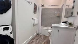 A compact bathroom with a shower, toilet, and a small sink area. - 6 min to Ski Hill / New & Modern / In Town (Fernie)
