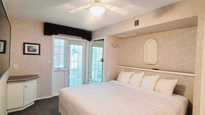 A bedroom with a bed, a ceiling fan, a window, and a door. - Mountain View Condo with Sofabed and Aircon (Fairmont Hot Springs)