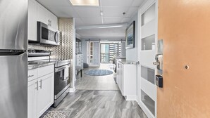 Una cucina moderna con elettrodomestici in acciaio inossidabile, mobili bianchi e piastrelle decorate.
