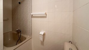 Une salle de bain équipée d’une baignoire, de toilettes et d’un porte-serviettes.