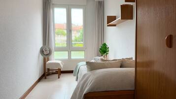 2 dormitorios, tabla de planchar con plancha, ropa de cama