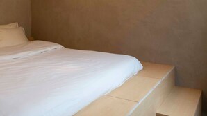 Un dormitorio con cama, una lámpara y una escalera.