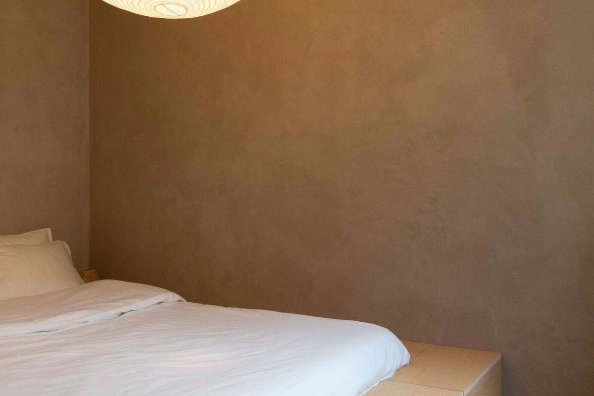 Ein Schlafzimmer mit einem Bett, einer Lampe und einer Treppe.