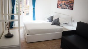 Un dormitorio con cama, mesitas de noche, lámpara y un cuadro en la pared.