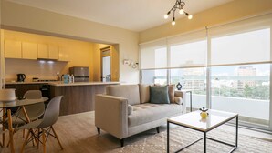 A modern living room with a sofa, coffee table, and dining area. - w*| Fantastic 2BR w/ modern balcony in Miraflores (Lima)