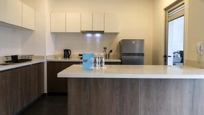 A modern kitchen with wooden cabinets, a stainless steel refrigerator, and a central island with a blue sign. - w*| Fantastic 2BR w/ modern balcony in Miraflores (Lima)
