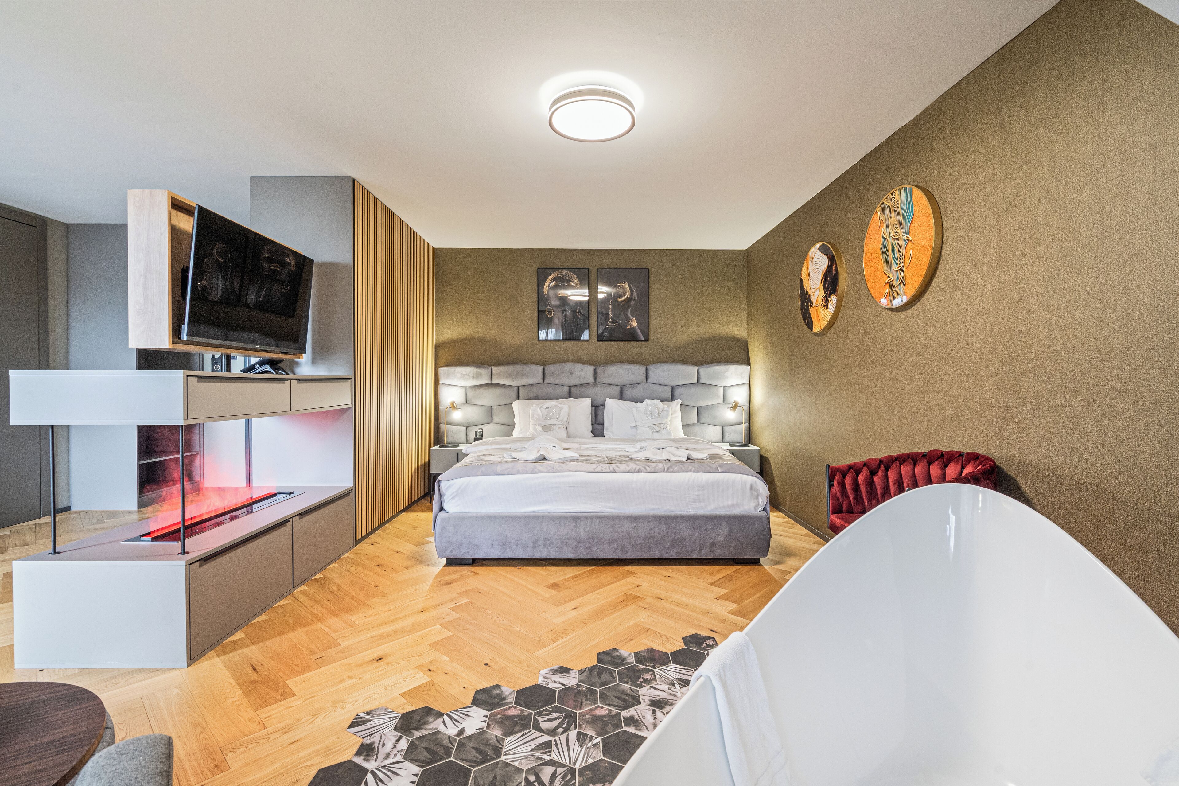 Une chambre à coucher moderne avec un lit, une télévision et une cheminée.