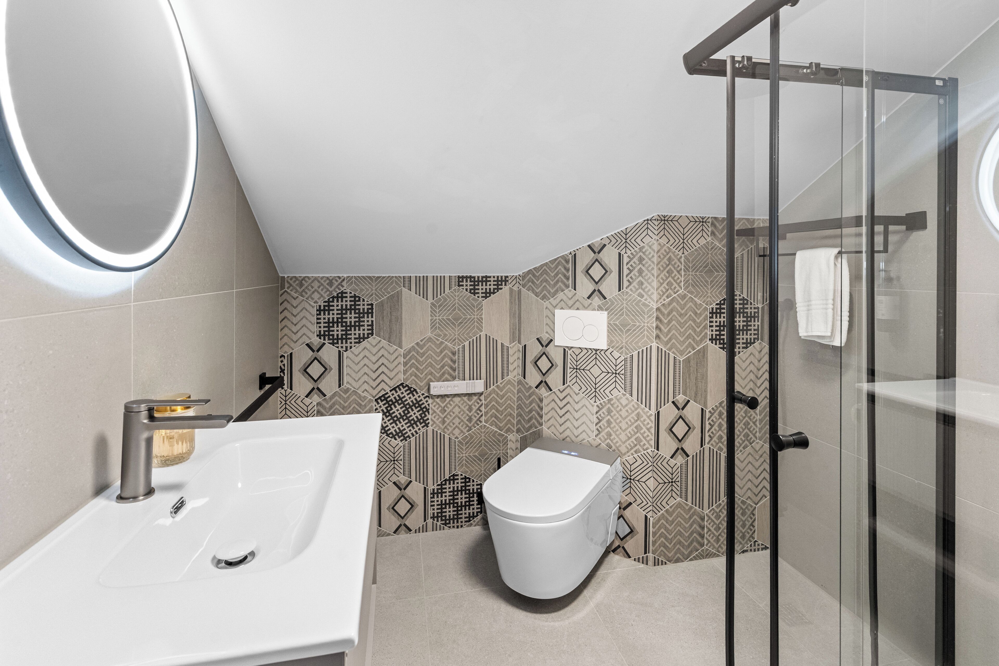 Ein modernes Badezimmer mit Waschbecken, Toilette und Duschkabine aus Glas.