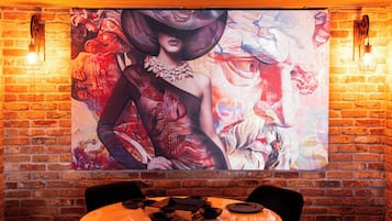 A restaurant with a brick wall and a large abstract painting.