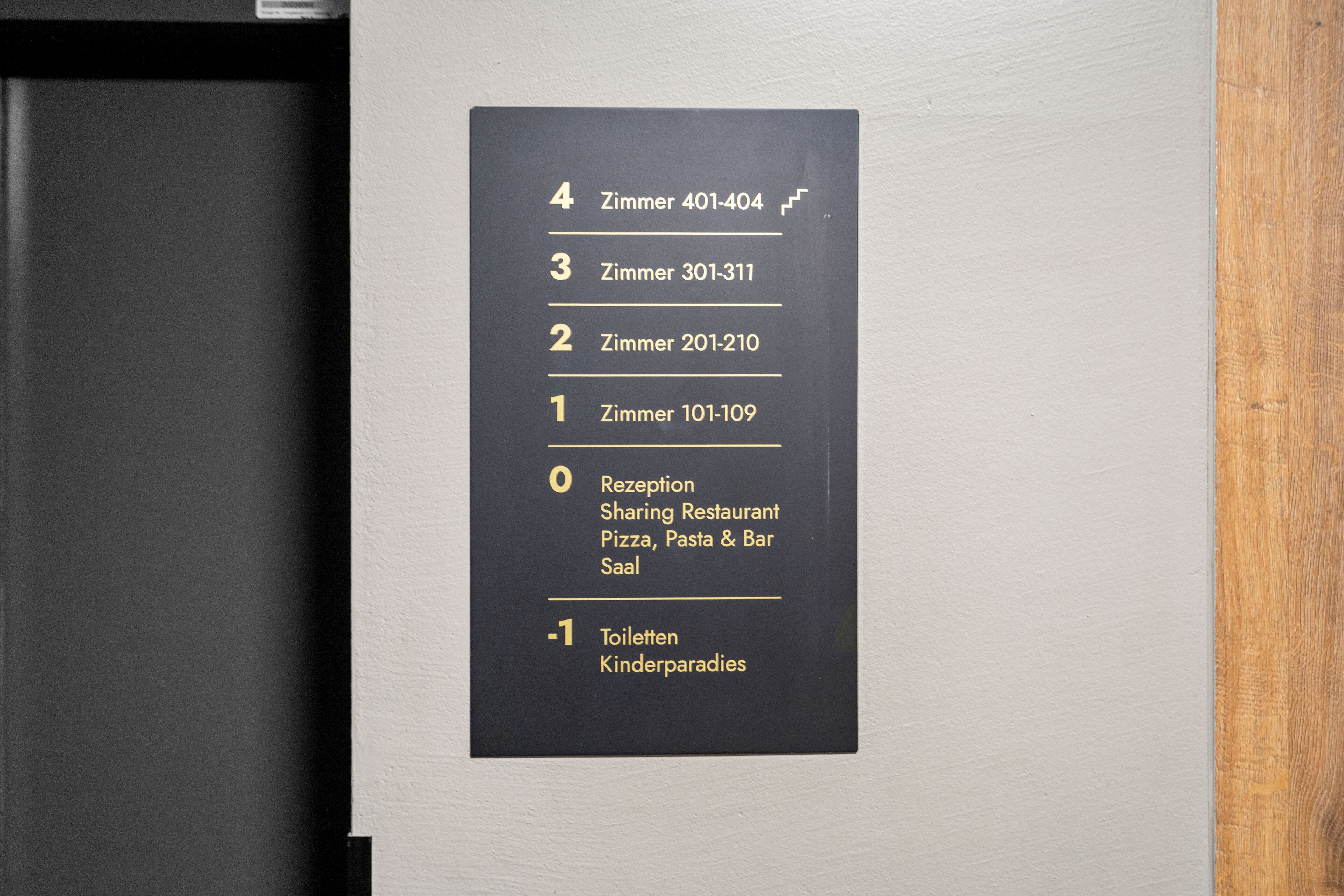 A hotel room directory with numbered doors leading to various rooms and amenities, including a reception, restaurant, and children's play area.
