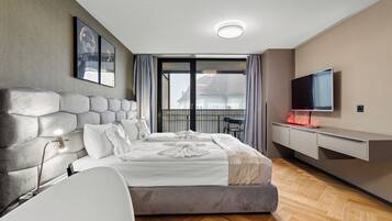 Un dormitorio moderno con una cama grande, un televisor de pantalla plana y un balcón con vistas.