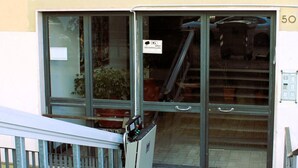 A building entrance with a glass door, a metal railing, and a staircase leading up. - Flegreo bed and breakfast (Naples)