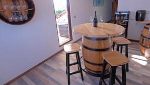 A dining area with a round wooden table, bar stools, and a wine rack. - Penthouse Stella (Pula)