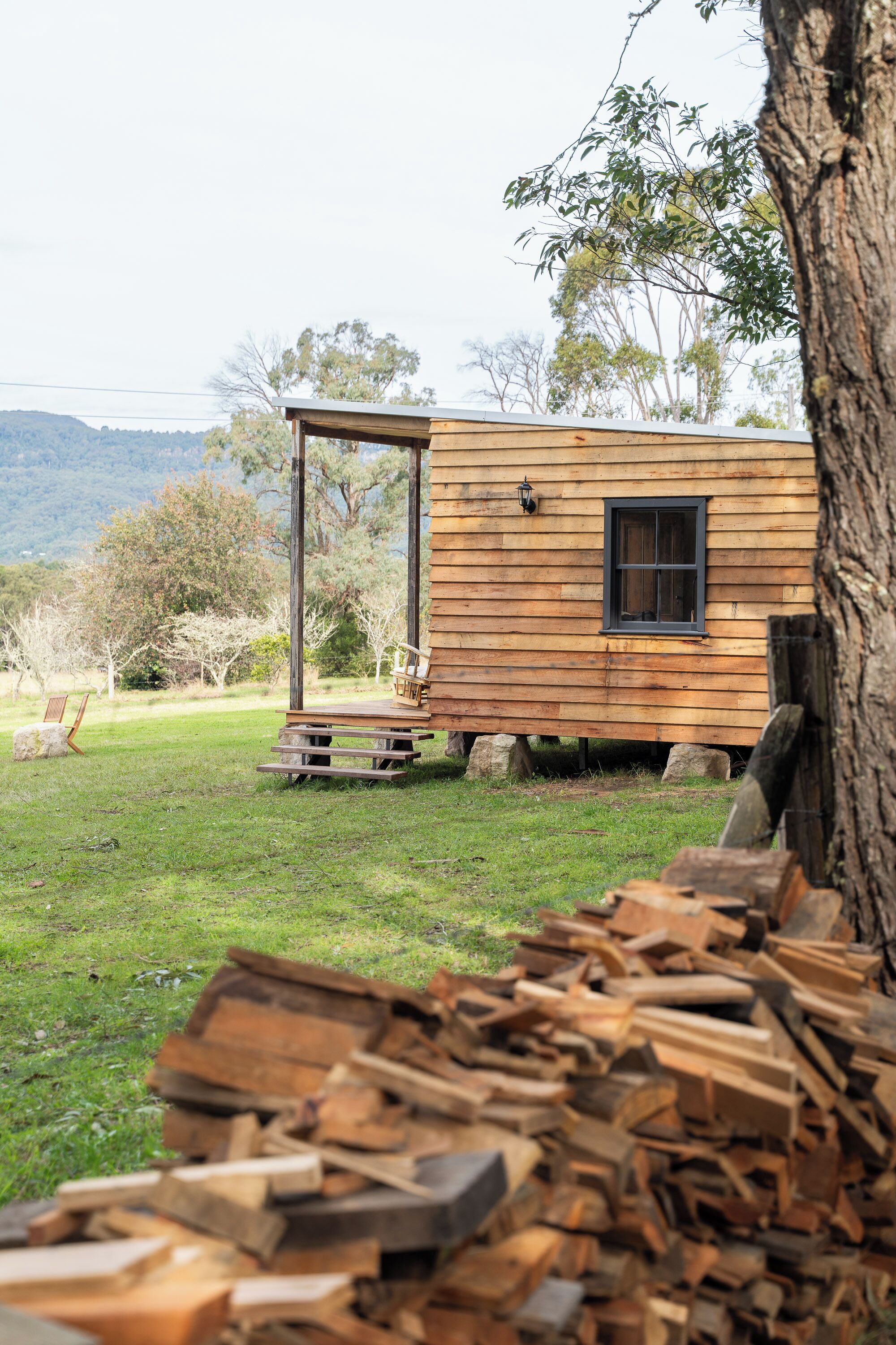 Una baita di legno con una porta, una finestra e un piccolo portico.