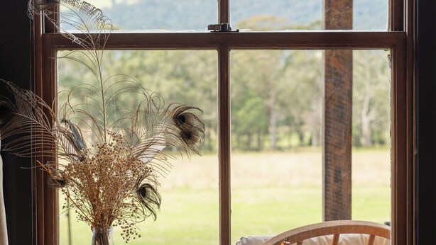 Una ventana con vistas a un paisaje verde y montañas.