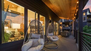 Eine Holzterrasse mit Hängestühlen und einem Essbereich.