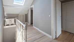 A spacious loft with a skylight, wooden flooring, and a white staircase. - Brussels EU Prestige residence (Brussels)