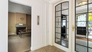 A hallway with a fireplace, a bench, and a door with a security keypad. - Brussels EU Prestige residence (Brussels)