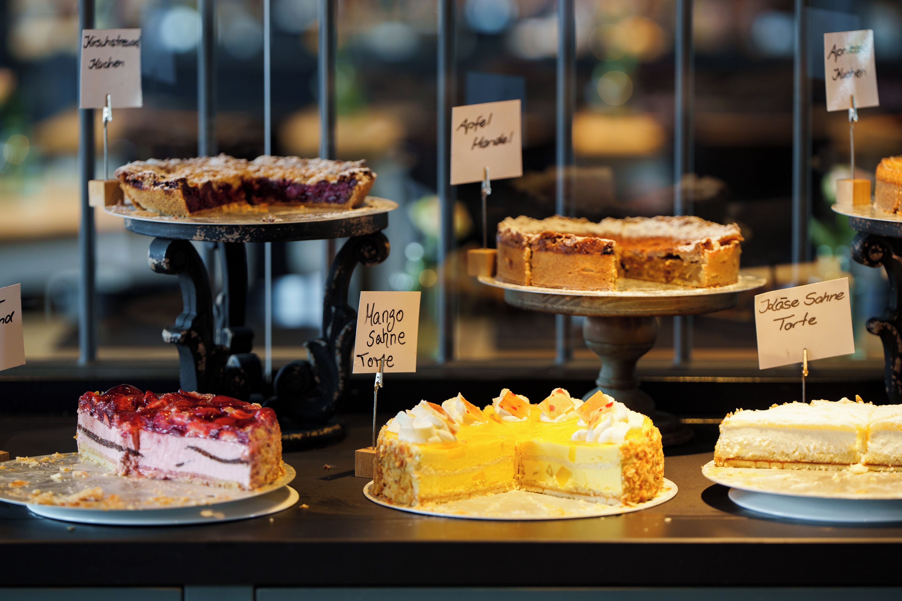 A display of various cakes with labels indicating their names.