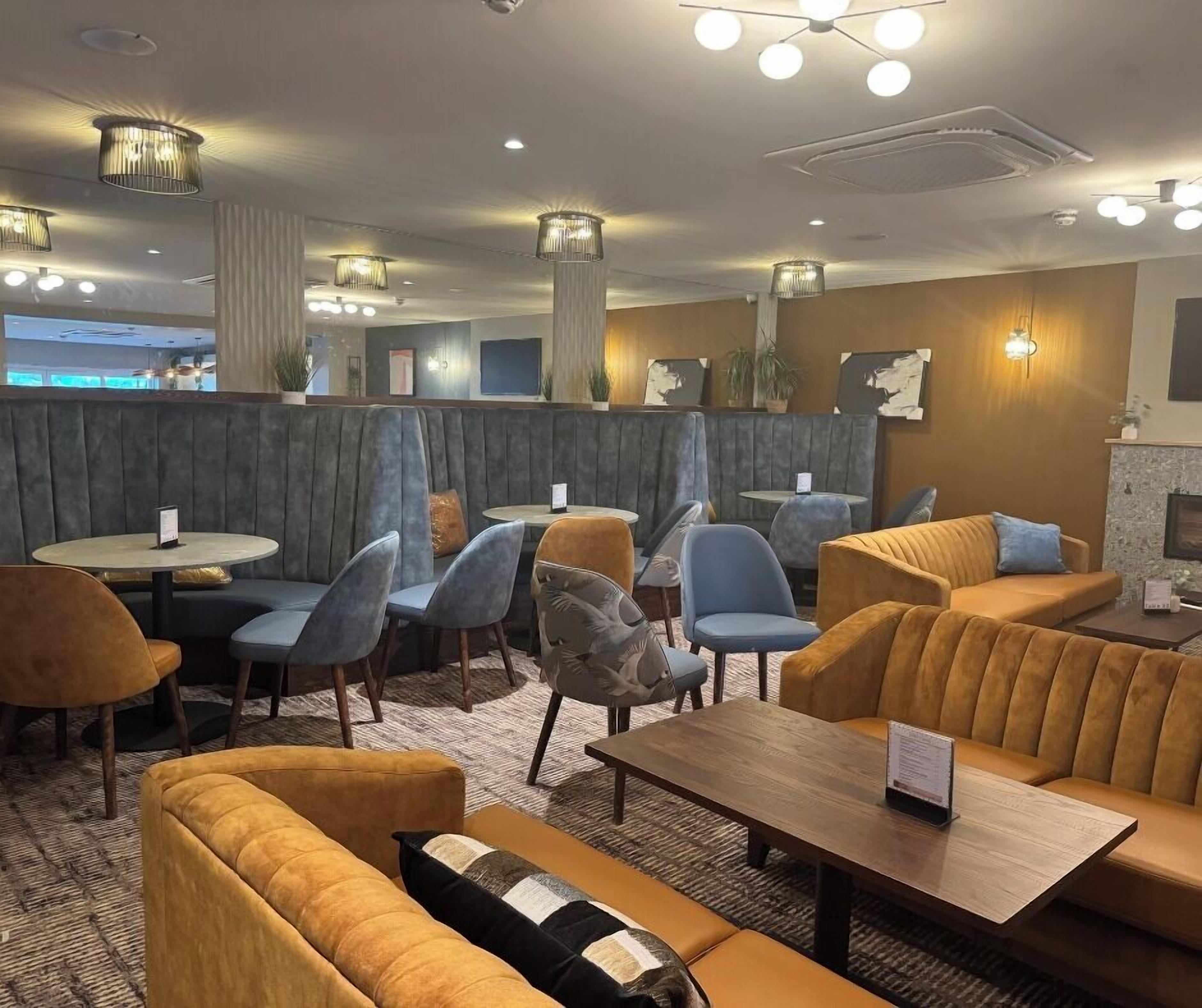 A modern interior with seating arrangements, tables, and decorative lighting.