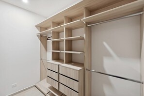 Ein moderner Kleiderschrank mit mehreren Regalen und Schubladen, ausgestattet mit schlichtem Design und einer neutralen Farbgebung.