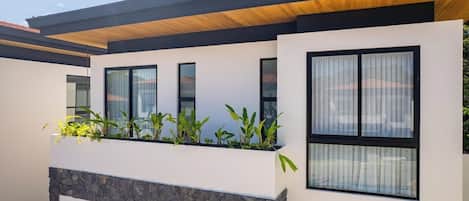 Un edificio moderno con techo plano, ventanas amplias y base de piedra.