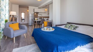 A modern hotel room with a large bed, a dining area, and a kitchenette. - Cap Océan by Interhome (Capbreton)