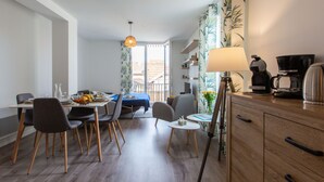 A modern dining area with a table set for two, a coffee maker, and a lamp on a wooden cabinet. - Cap Océan by Interhome (Capbreton)