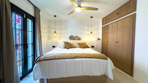 A bedroom with a large bed, wooden wardrobe, and a ceiling fan. - Casa Gina Old Town Marbella Center 4 Bedrooms (Marbella)