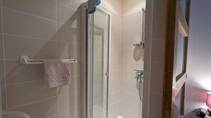 A modern bathroom with a glass shower enclosure, a towel rack with a pink towel, and a toilet. - Countryside Retreat with Spacious Grounds, Pool Access, and Family-Friendly Amenities (Pérassay)
