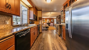 A kitchen with wooden cabinets, stainless steel appliances, and a central island. - Reflections Lakeview By Tahoe Getaways - Hot Tub & Buoy, Dog OK (Carnelian Bay)