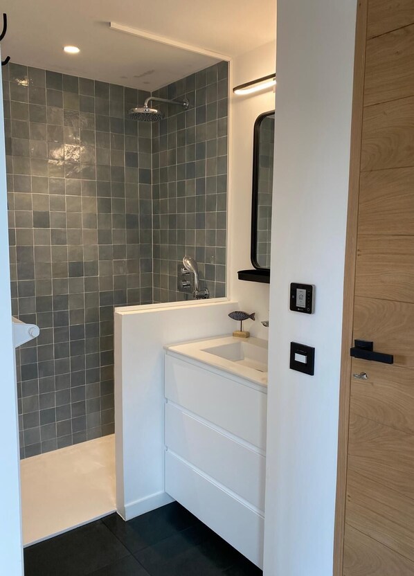 A modern bathroom with a shower, a white vanity, and a mirror. - Villa 15 pers - Spa & Hammam - 5 rooms - La Trinité-sur-Mer (La Trinité-sur-Mer)