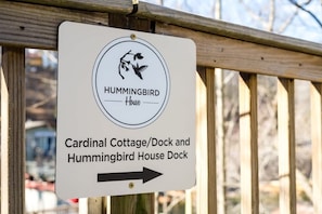 Schild für Hummingbird House mit Pfeil zu Cardinal Cottage/Steg und Hummingbird House Steg.