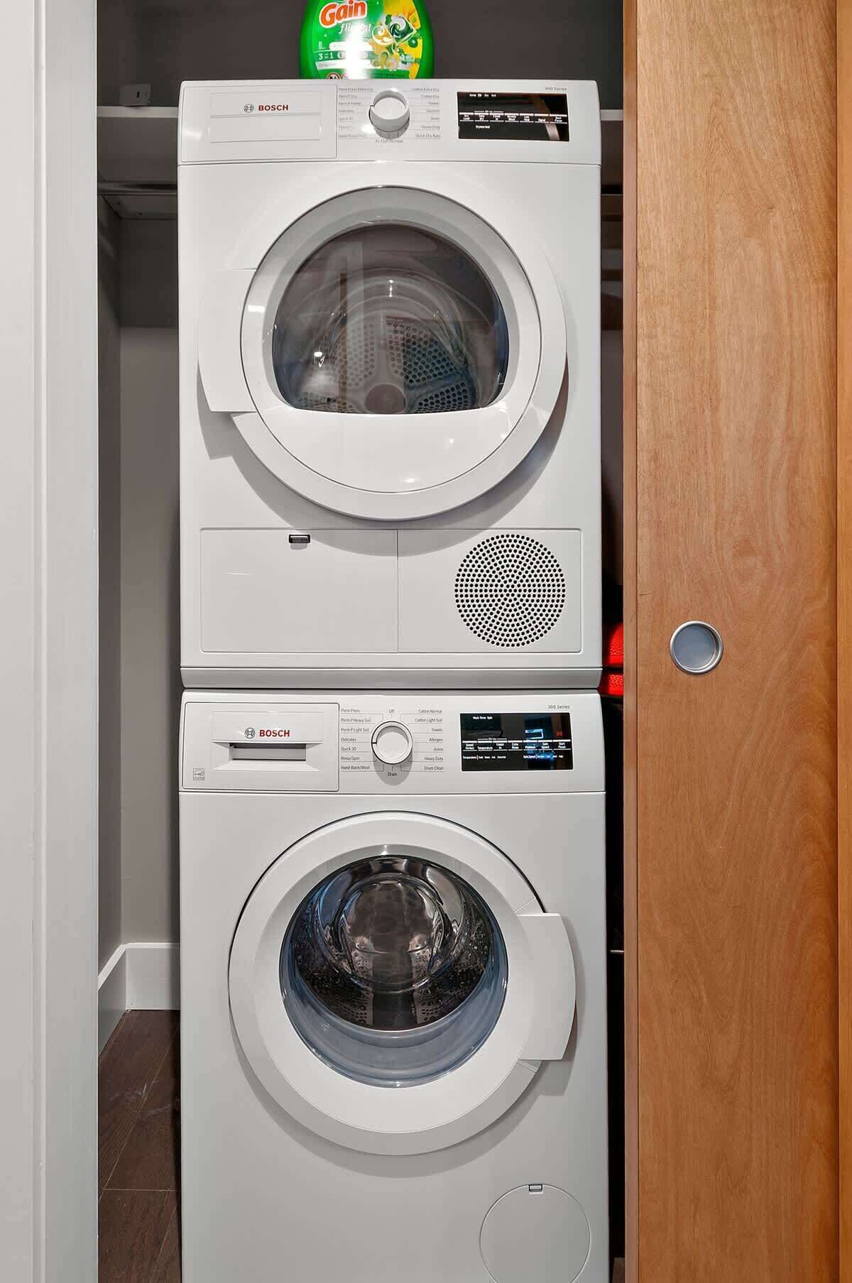 A stacked washer and dryer unit in a laundry room.