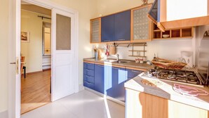 A kitchen with blue cabinets, a gas stove, and a wooden countertop. - Lovely 4 bedrooms apartment 30m SanGiovanni metro (Roma)