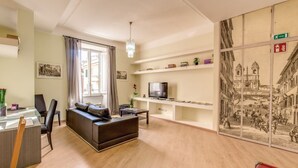 A modern living room with a sofa, TV, and shelves. - Lovely 4 bedrooms apartment 30m SanGiovanni metro (Roma)