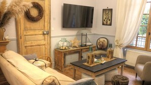 Uma sala de estar aconchegante com um sofá, uma mesa de centro, uma televisão e uma poltrona com tema de urso.