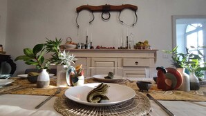 A dining table set with plates, cutlery, and a woven placemat. - Private Stone Cottage with Starlink & Lake Views - Remote Workers' Dream! (Montecchio)