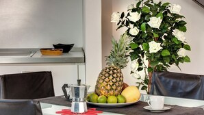 Ett matbord med en ananas, limefrukter och en vit kopp på en tallrik.