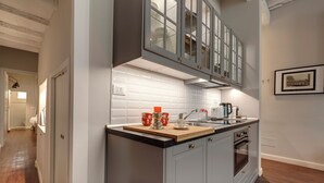 A modern kitchen with grey cabinets, a black countertop, and a stainless steel oven. - Mamo Florence - Cloe Apartment (Florence)