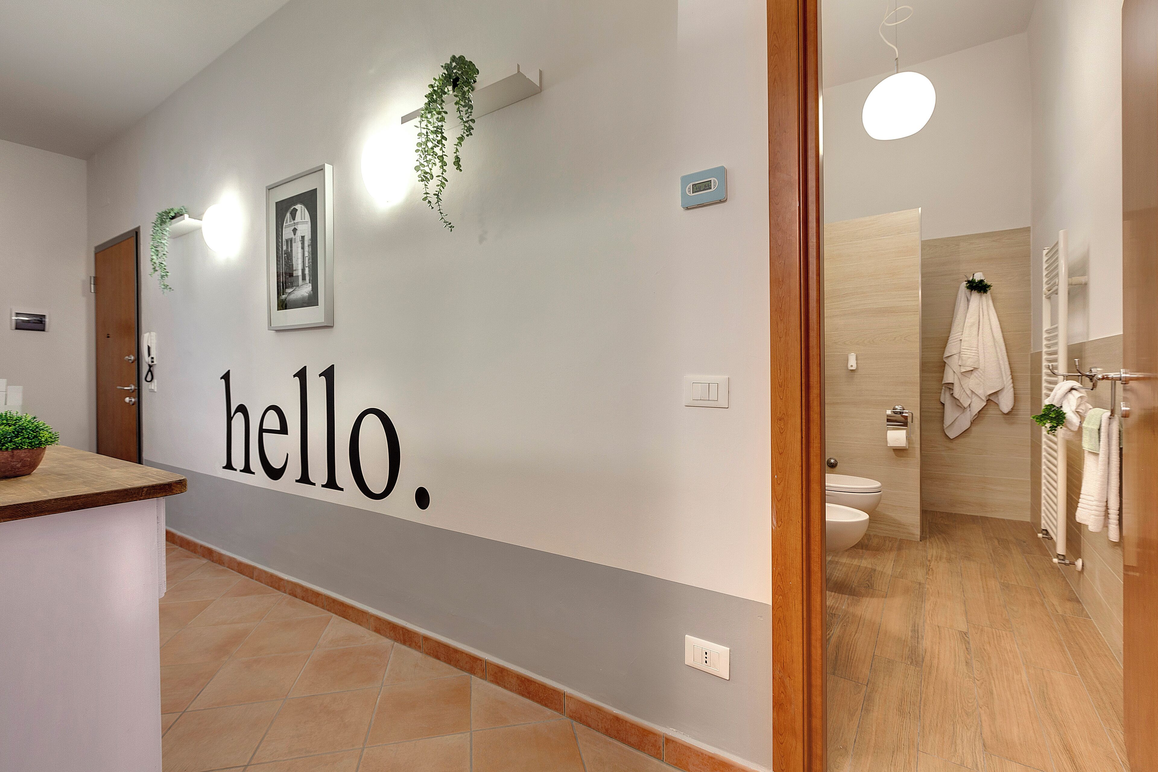 Een moderne badkamer met toilet, wastafel en handdoekhouder.