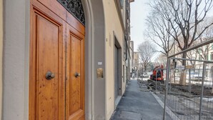 Un estrecho callejón con una puerta de madera y una reja de metal.