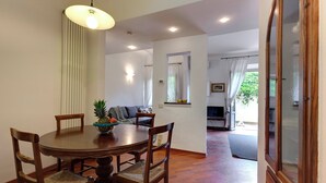 Un comedor con una mesa redonda de madera, cuatro sillas y una lámpara colgante.