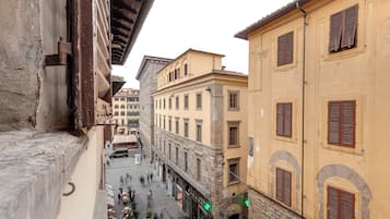 Una stretta via fiancheggiata da edifici, con balconi e un mix di stili architettonici.