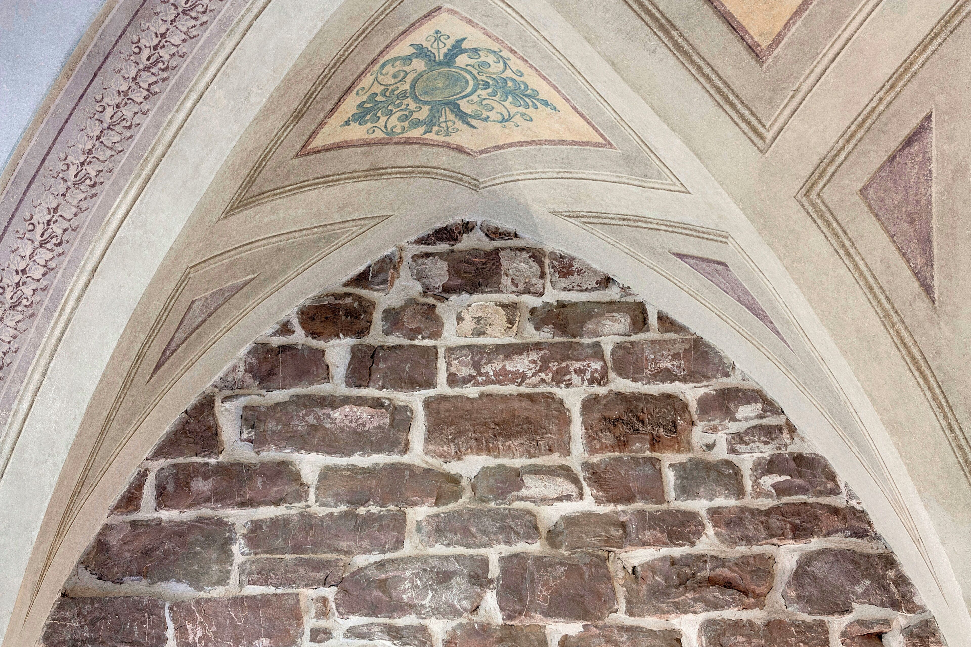 A stone archway with a decorative emblem above it.